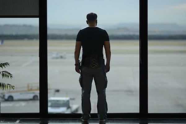 Man in an airport looking out of a window