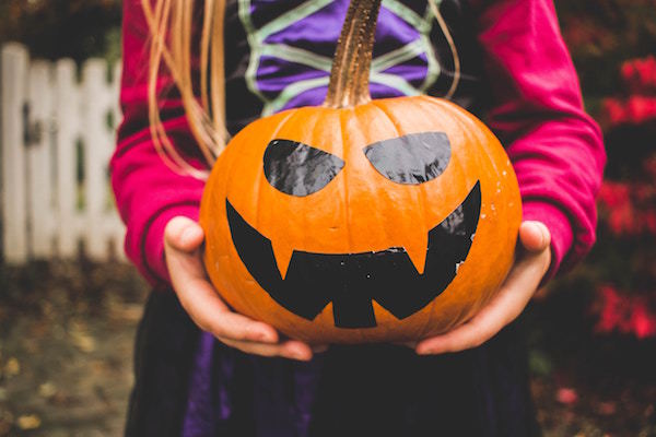 child holds a pumpkin