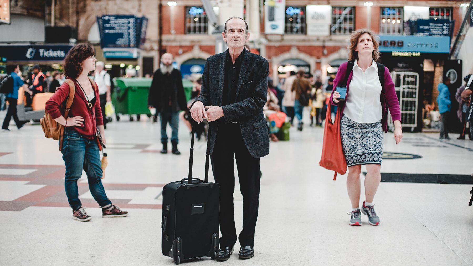 three people looking at airport screen