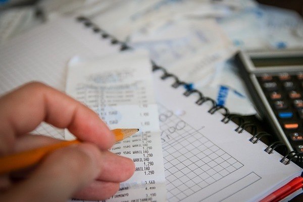 hand with pencil over receipt for self transfer flight