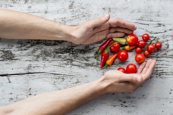 two hands grabbing vegetables