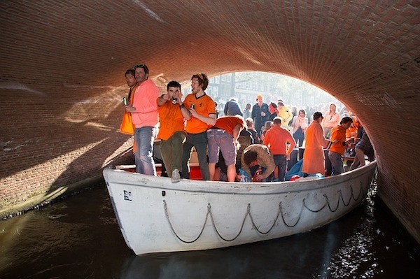 men wearing orange on a boat at King's Day in Amsterdam