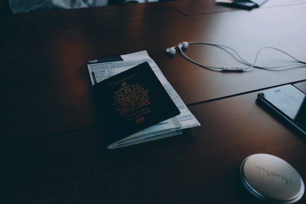 passport and customs form on table next to headphones