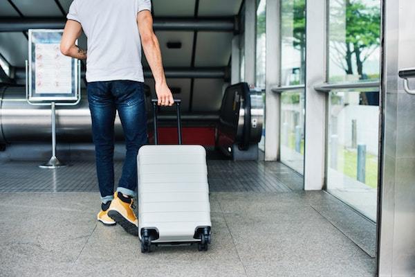 homem a puxar mala no aeroporto