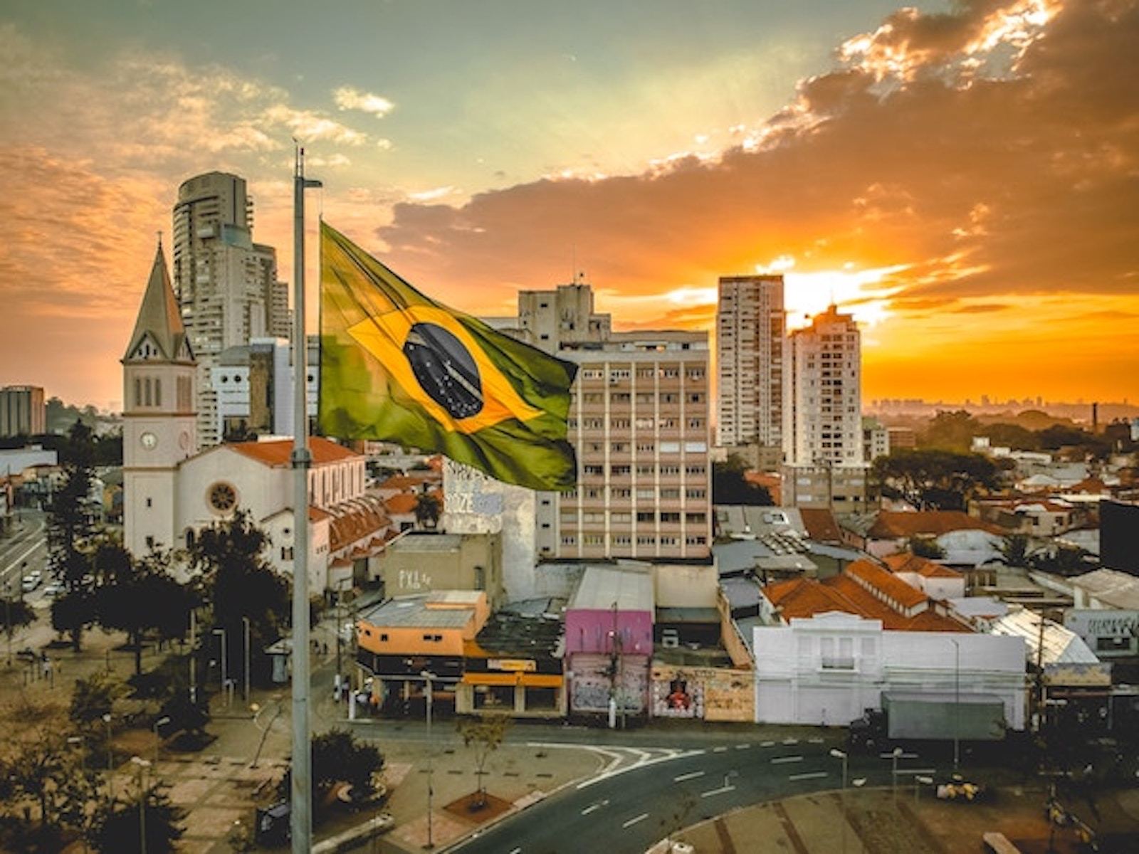 Brazil flag in front of sunset